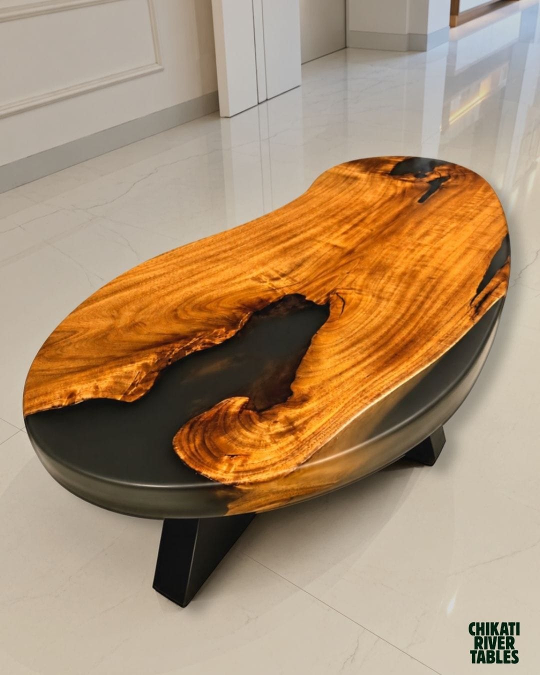 Free-form acacia table with grey resin pooling through its live edges