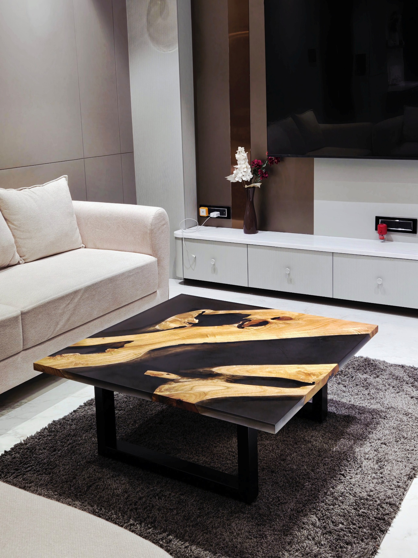 Square black resin river table in a living room